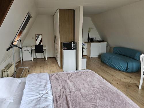a bedroom with a bed and a couch in a room at City Centre Suite in Hoorn
