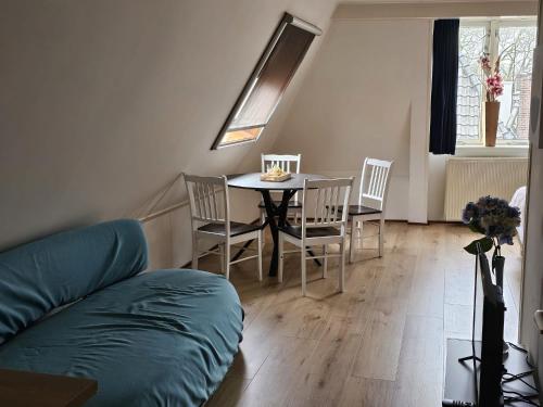 een woonkamer met een tafel en stoelen en een bank bij City Centre Suite in Hoorn