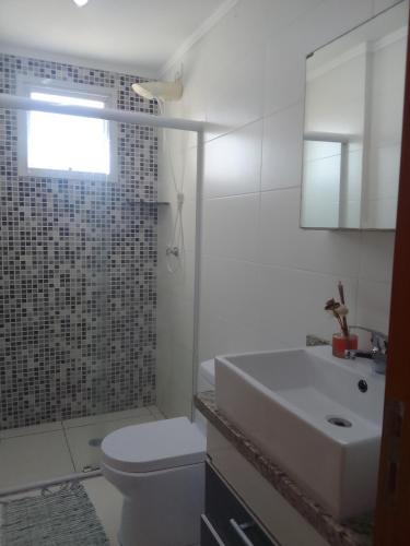 een badkamer met een wastafel, een toilet en een douche bij Praia in Praia Grande