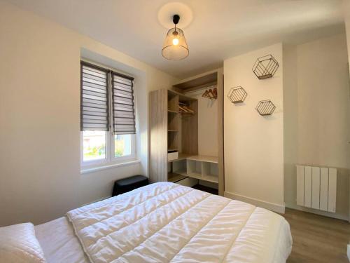 une chambre avec un lit blanc et une fenêtre dans l'établissement Bel appartement rénové 5 personnes au centre ville de PERROS-GUIREC - Réf 957, à Perros-Guirec