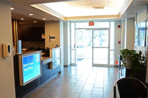 an office lobby with a large tv and a counter at Motel 6-West Des Moines, IA in West Des Moines
