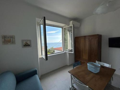 ein Wohnzimmer mit einem Sofa und einem großen Fenster in der Unterkunft Casa Dalidà in Tellaro