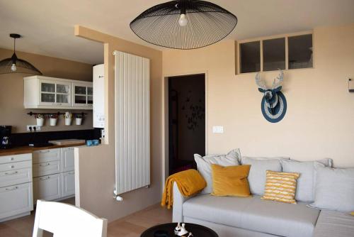 un salon avec un canapé et une cuisine dans l'établissement Appartement entièrement rénové avec SUPERBE VUE sur la Baie Sainte-Anne à TREGASTEL - Ref 96, à Trégastel