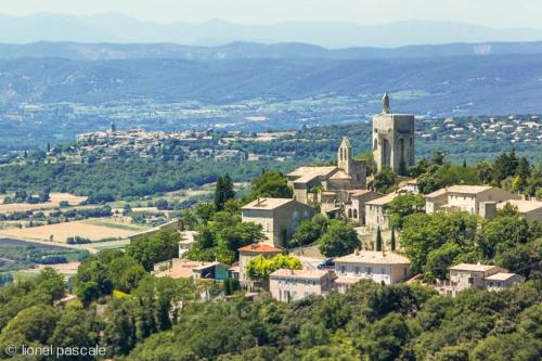 un pueblo en la cima de una colina con una iglesia en Appartement neuf 36m2 climatisé, en Chamaret