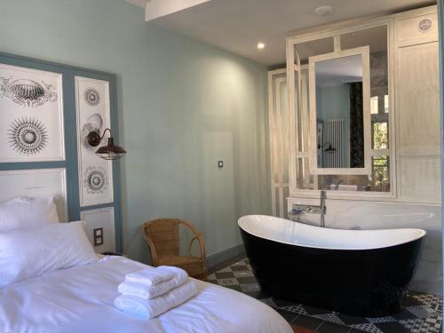 ペズナにあるMes à Moi in Pezenas - Appartements de charme - Baignoire Balnéoのベッドルーム1室(バスタブ、ベッド1台、バスタブ付)