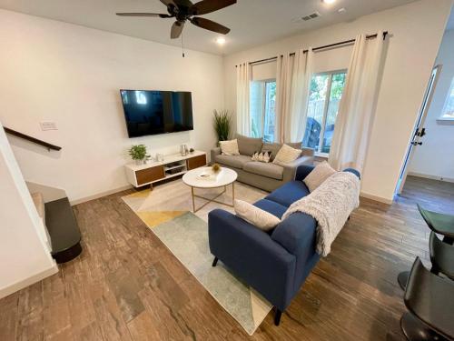a living room with a couch and a tv at Stylish townhome near AT&T Stadium, Globe Life, Six Flags & More in Arlington