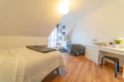 - une chambre mansardée avec un lit et un bureau dans l'établissement Le central, à Mulhouse