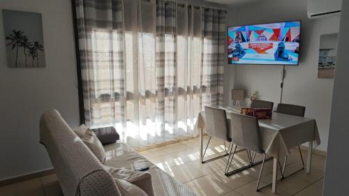 a living room with a table and chairs and a television at Casa Alisios - Telde in Telde