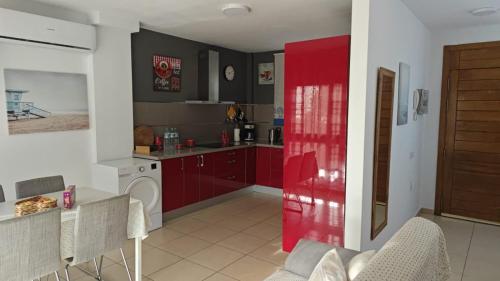 a kitchen with red cabinets and a red door at Casa Alisios in Telde