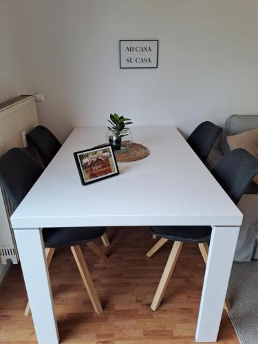 una mesa blanca y sillas con una planta en Phantasialand Appartement 6 PERS, en Brühl
