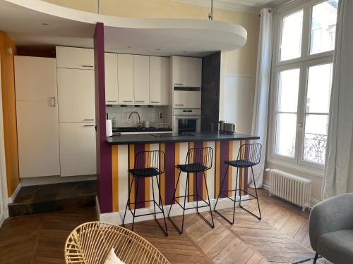 une cuisine avec un comptoir et des tabourets dans une pièce dans l'établissement Une escapade au cœur de Tours, à Tours