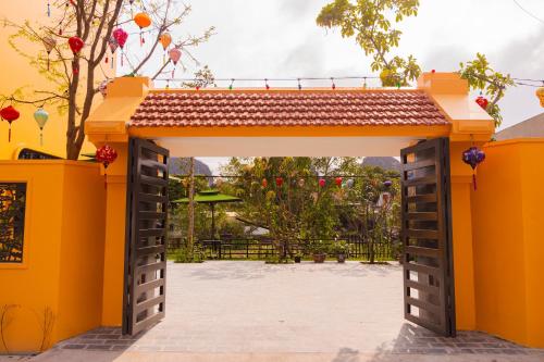 an orange gate with a roof on top at La Mai Tam Coc Homestay in Ninh Binh