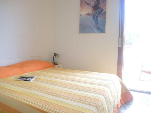 a bed in a bedroom with a picture on the wall at CAVALLINO in Bibione