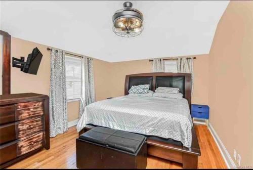 a bedroom with a large bed and a dresser and a bed sidx sidx sidx at Entire home- pool, gym, theater. 10 min from NYC. in Yonkers