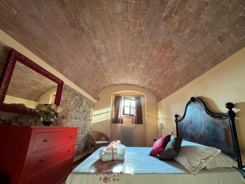 a bedroom with a bed with a red dresser at Suite Gabri, Stiozzi Ridolfi in Certaldo