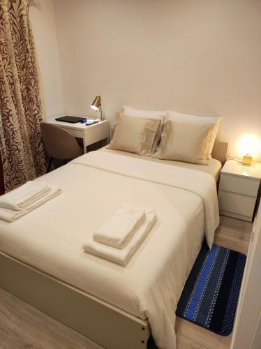 a bedroom with a large bed with towels on it at Vista Panorâmica Amadora RC in Amadora