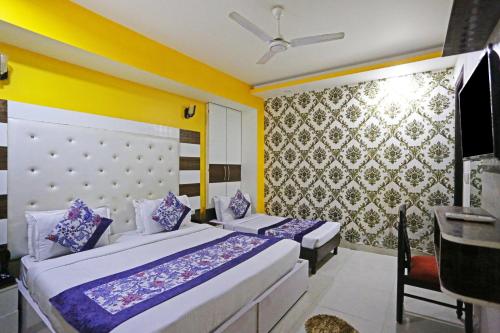 sypialnia z 2 łóżkami i żółtą ścianą w obiekcie Hotel Star Inn - Delhi Airport, Mahipalpur, Aerocity w Nowym Delhi