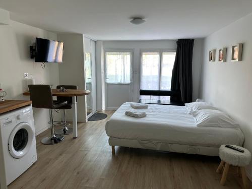 a bedroom with a bed and a desk and a table at Studio calme, la campagne a 5 minutes de la ville in Fondettes