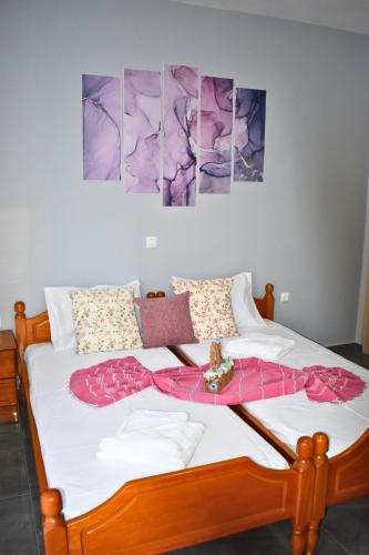 a bedroom with a bed with four pictures on the wall at Venice Apartments in Limenaria