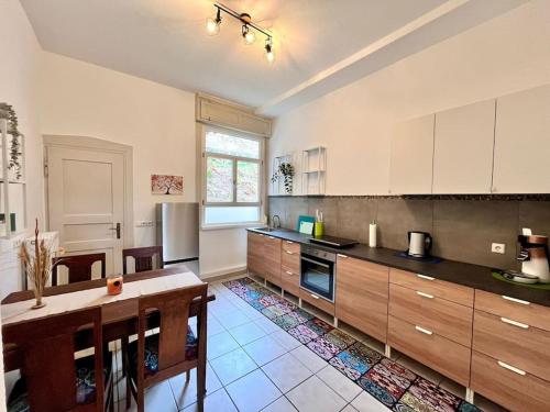 une grande cuisine avec des placards en bois et une table dans l'établissement Gemütliches 1 Zimmer- Apartment in Neuenbürg, à Neuenbürg