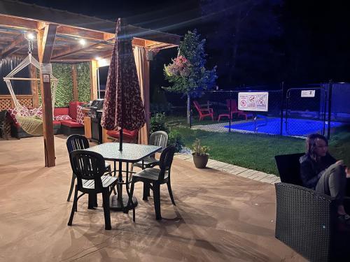 a table and chairs in a patio with a tent at Le Loft Riverstone CITQ 3O1849 in Saint Pierre de Broughton