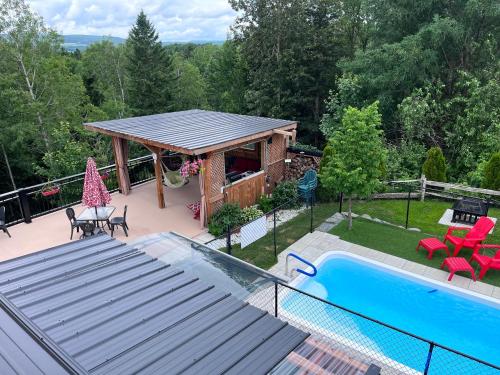 a house with a gazebo and a swimming pool at Le Loft Riverstone in Saint Pierre de Broughton