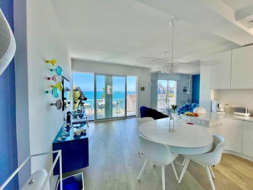 une cuisine et un salon avec une table et des chaises blanches dans l'établissement 2P Bonjour Soleil (Sea View/Terrasse&AC), à Nice
