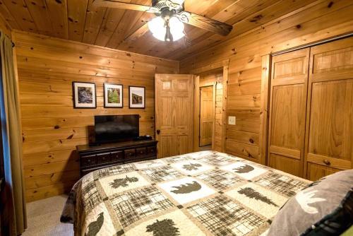 a bedroom with a bed and a flat screen tv at Private Creekside Cabin+Hot Tub,Pool Table, & Pets in Ellijay