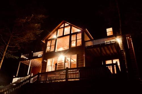 a large wooden house at night with lights at Private Creekside Cabin+Hot Tub,Pool Table, & Pets in Ellijay
