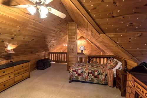 a bedroom in a log cabin with a bed at Private Creekside Cabin+Hot Tub,Pool Table, & Pets in Ellijay