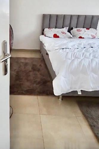 a bedroom with a bed with white sheets on it at Samira in Rufisque