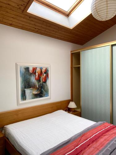 une chambre avec un lit avec un tableau sur le mur dans l'établissement Gîtes Côte de Jade, proche plage et commerces, de 2 à 6 personnes, à La Bernerie-en-Retz