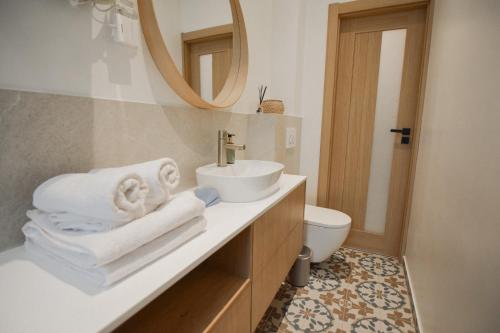a bathroom with a sink and a toilet with towels at Apartament Sikorskiego in Poznań