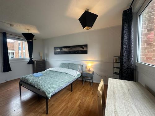 a bedroom with a bed and a table and a window at Mile End House in London