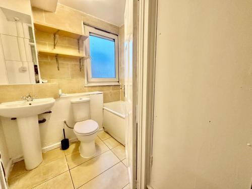 a bathroom with a white toilet and a sink at Mile End House in London