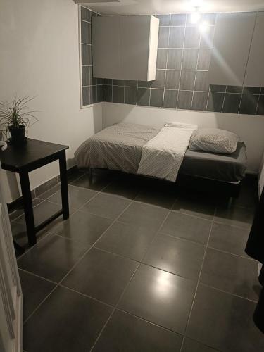 sypialnia z łóżkiem i stołem w pokoju w obiekcie Tiny house - Gare Paris Aeroport w mieście Drancy