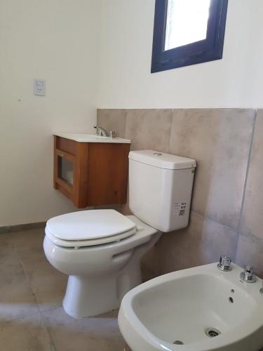 a bathroom with a white toilet and a sink at Atila de montaña in San Martín de los Andes