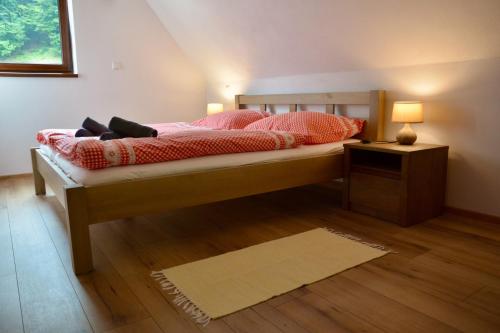 a bedroom with a bed with a lamp on a wooden floor at Chata na Trávniku 302 in Horná Turecká