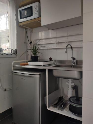 une petite cuisine avec un évier et un évier dans l'établissement Tiny house - Gare Paris Aeroport, à Drancy