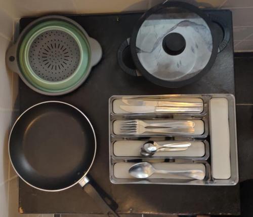 a tray with utensils and a strainer and a frying pan at Tiny house - Gare Paris Aeroport in Drancy