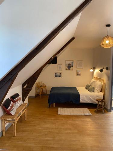 een slaapkamer met een bed op zolder bij Studio un cocon à la campagne in Saint-Samson-sur-Rance