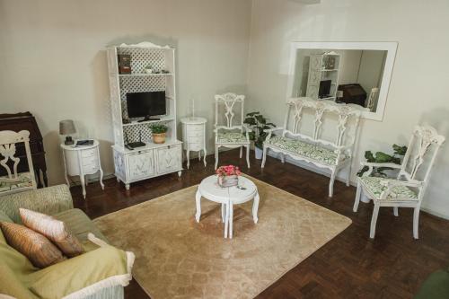 sala de estar con sillas blancas y mesa en La Casina en Uruguaiana