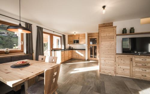 a kitchen and dining room with a wooden table at Enzianhof - Nature Apartments in San Giovanni in Val Aurina