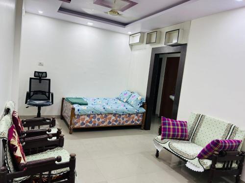 uma sala de estar com uma cama e duas cadeiras em AnubhavGruha Holiday Home Nagpur em Nagpur