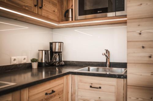 a kitchen with a sink and a microwave at Enzianhof - Nature Apartments in San Giovanni in Val Aurina