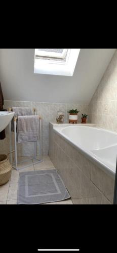 a bathroom with a large white tub and a sink at Studio Cocooning in Saint-Samson-sur-Rance