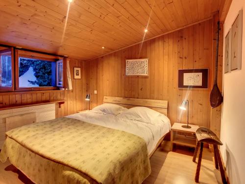 ein Schlafzimmer mit einem Bett in einem Holzzimmer in der Unterkunft Arolla 8 in Verbier