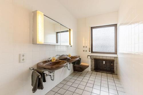 Baño con 2 lavabos y espejo en Wohnung mit Küche, Balkon, Netflix im Herzen von Neheim, en Arnsberg