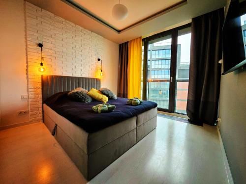 a bed in a room with a large window at Apartamenty Point of View in Bydgoszcz