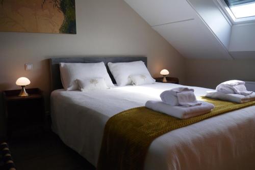 a bedroom with a large bed with towels on it at Chambres d'Hôtes La mésange à tête Bleue in Pierre-de-Bresse